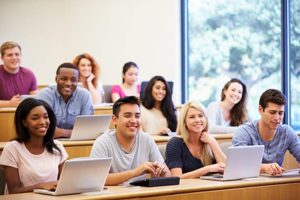 Students Using Laptops And Digital Tablets In Lecture