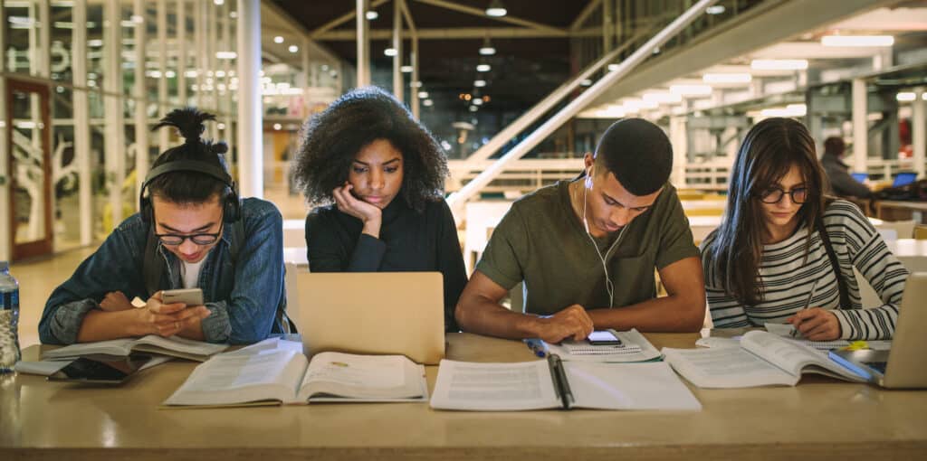 Multi-ethnic students sitting at college library