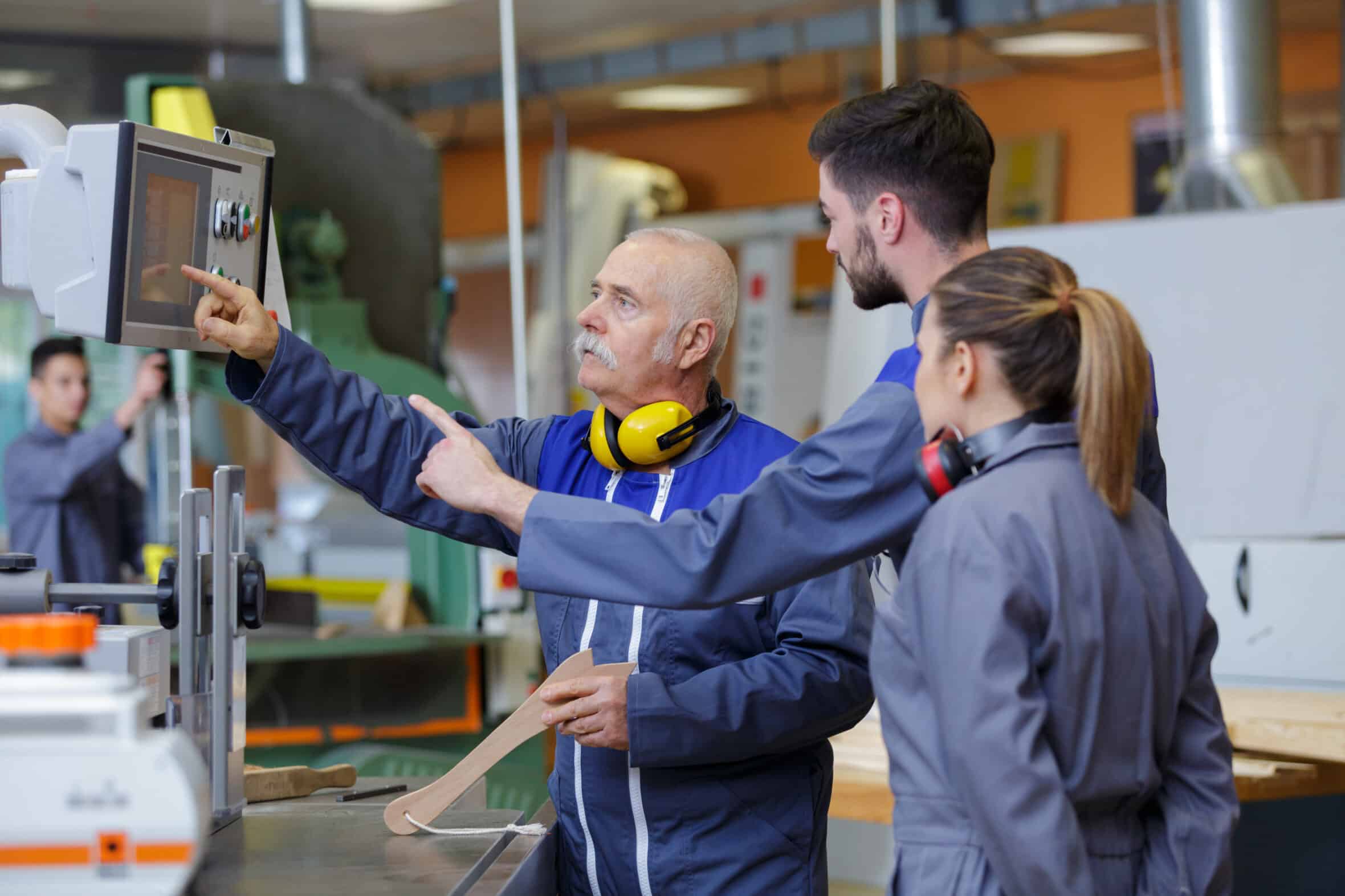 engineer and apprentice using automated machinery